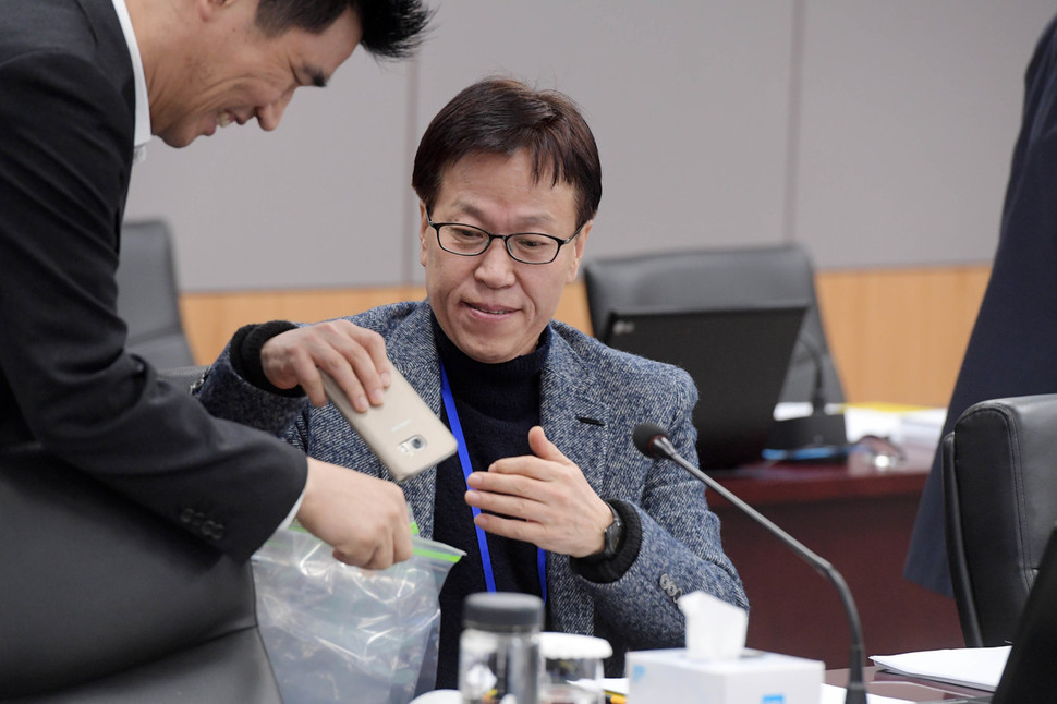 증권선물위원회 민간 위원인 이상복 서강대 교수가 31일 서울 종로구 정부서울청사에서 열린 삼성바이오로직스 분식회계 의혹에 대한 재감리 안건 논의에 앞서 휴대전화를 제출하고 있다. 공동취재사진