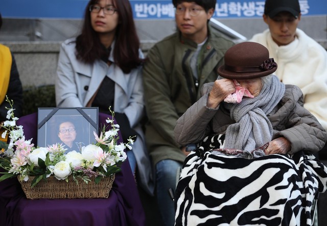 지난달 31일 종로구 주한일본대사관 앞에서 열린 일본군 위안부 피해자 문제 해결 촉구 수요집회에 참석한 이옥선 할머니가 지난 26일 별세한 고 하점연 할머니의 영정을 바라보다 눈물을 훔치고 있다. 연합뉴스