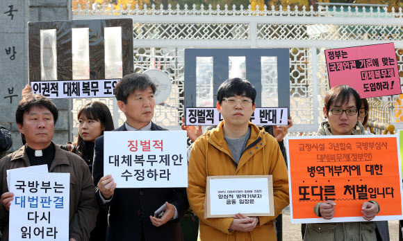 5일 오전 서울 용산구 국방부 앞에서 열린 ‘정부의 양심적 병역거부 징벌적 대체복무제안 반대’ 기자회견에서 병역 거부자 및 사회단체 회원들이 정부의 대체복무제 방안 수정을 촉구하는 손팻말을 들고 있다. 연합뉴스