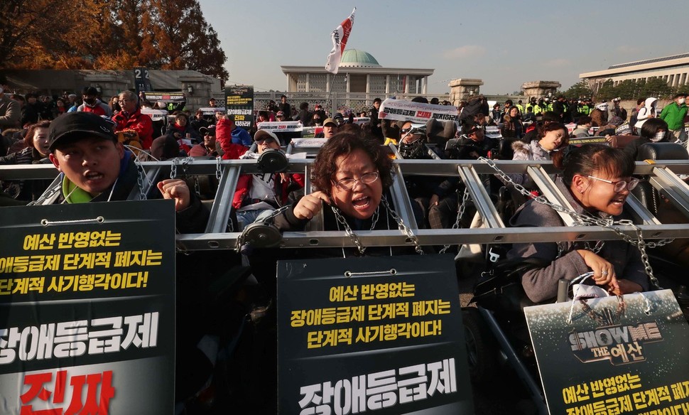 장애인들이 14일 오후 국회 앞에서 장애등급제 폐지를 요구하며 사다리와 쇠사슬로 몸을 묶고 농성하고 있다. 박종식 기자 anaki@hani.co.kr