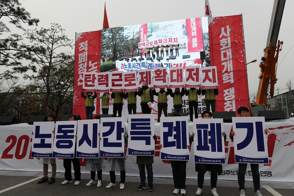 전국민주노동조합총연맹 조합원들이 21일 오후 서울 여의도 국회 앞에서 '탄력근로제 확대 저지' 등의 구호를 쓴 손팻말을 들어보이고 있다. 백소아 기자