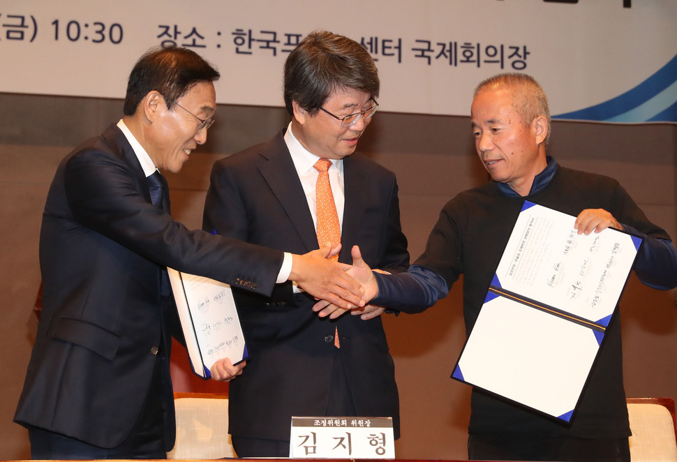 23일 오전 서울 중구 프레스센터에서 열린 삼성전자-반올림 중재판정 이행합의 협약식에서 삼성전자 김기남 대표이사(왼쪽부터), 김지형 조정위원장, 황상기 반올림 대표가 협약서를 들고 악수하고 있다. 신소영 기자 viator@hani.co.kr
