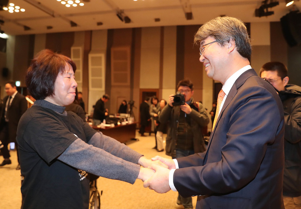 23일 오전 서울 중구 프레스센터에서 열린 삼성전자-반올림 중재판정 이행합의 협약식이 끝난 뒤 피해자 한혜경씨의 어머니 김시녀(왼쪽)씨가 김지형 조정위원장의 손을 잡고 울먹이고 있다. 신소영 기자 viator@hani.co.kr