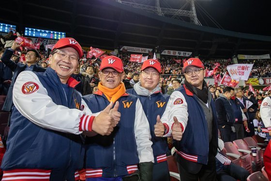 에스케이(SK)그룹 총수일가 4형제가 13일 서울 잠실 야구장에서 한국시리즈 6차전을 관람하다가 찍은 기념사진. 왼쪽부터 최창원 SK디스커버리 부회장, 최신원 SK네트웍스 회장, 최태원 SK그룹 회장, 최재원 SK그룹 수석부회장. SK그룹 제공