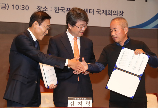 23일 오전 서울 중구 프레스센터에서 열린 삼성전자-반올림 중재판정 이행합의 협약식에서 삼성전자 김기남 대표이사(왼쪽부터), 김지형 조정위원장, 황상기 반올림 대표가 협약서를 들고 악수하고 있다. 신소영 기자 viator@hani.co.kr