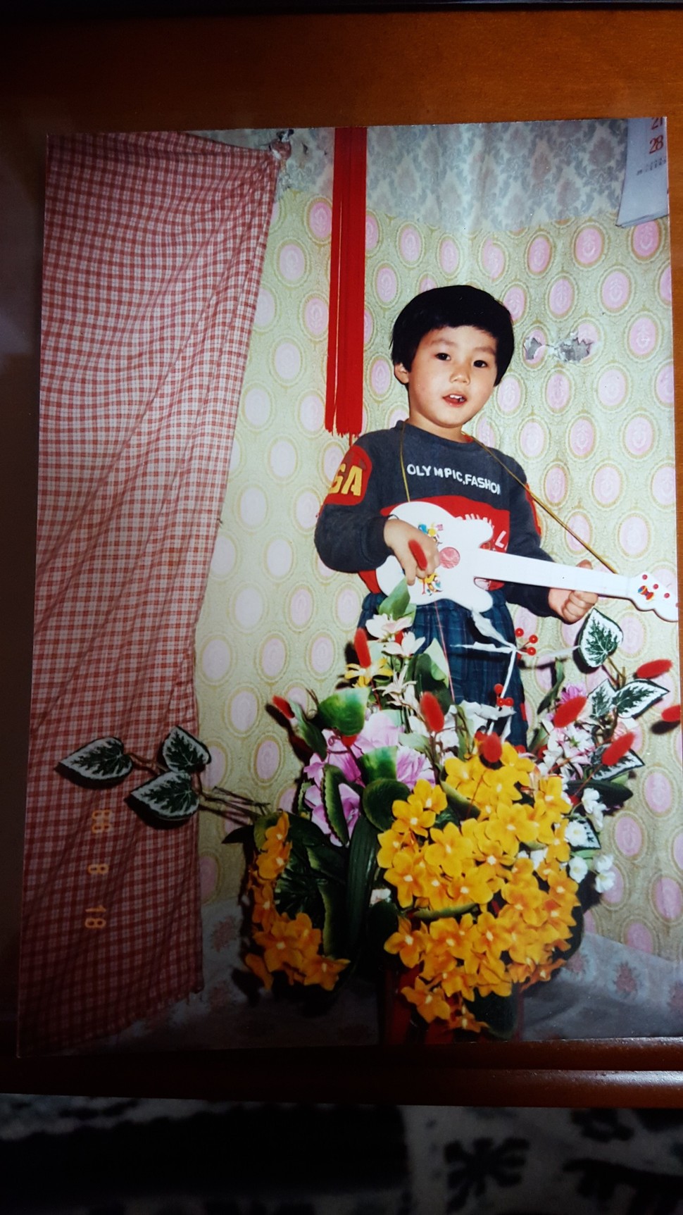1986년 2살. 서울 금천구 독산동 단칸방에서 살 때. 장난감 기타를 치며 놀았다.