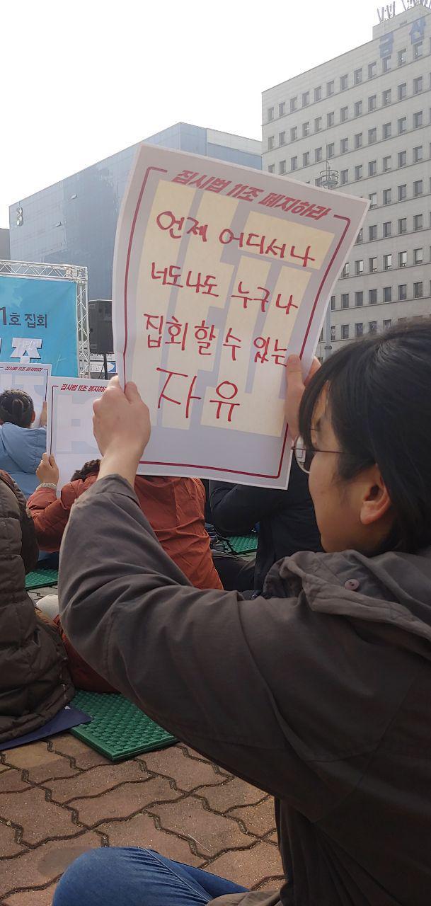 11월27일 오전 11시30분 서울 여의도 국회 앞에서 열린 ‘집시법 11조 폐지 선언 대회’에서 한 참가자가 ‘집회의 자유’를 요구하는 팻말을 들고 있다. 사진 장예지 기자