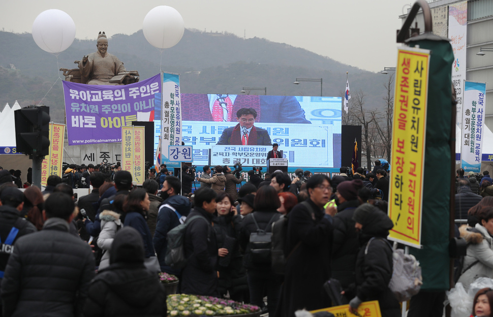 29일 오후 서울 종로구 광화문광장에서 열린 2018년 전국 사립유치원 원장·설립자·학부모대표 총궐기대회 뒤로 시민단체 ‘정치하는 엄마들’이 띄운 메시지가 보이고 있다. 백소아 기자