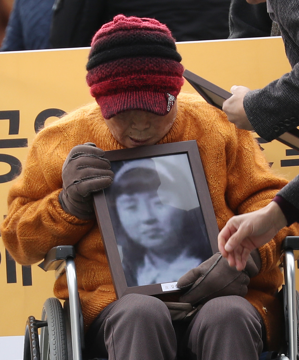 일제 강제징용 피해자 및 조선여자근로정신대 피해자들이 전범기업인 미쓰비시 중공업을 상대로 낸 손해배상 청구소송 상고심 선고 예정된 29일 오전 서울 서초구 대법원 앞에서 피해자 김성주 할머니가 다른 피해자의 영정을 들고 있다. 2018.11.29 연합뉴스