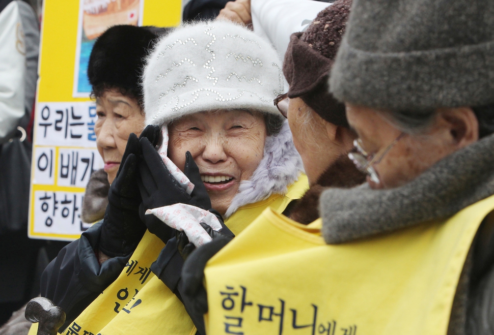 제999차 일본군 위안부 문제 해결을 위한 수요집회에참석한 김순옥 할머니(왼쪽 둘째)가 2011년 12월 7일 낮 서울 종로구 중학동 주한 일본대사관 앞에서 핫팩을 얼굴에 대며 활짝 고 있다. 신소영 기자 viator@hani.co.kr