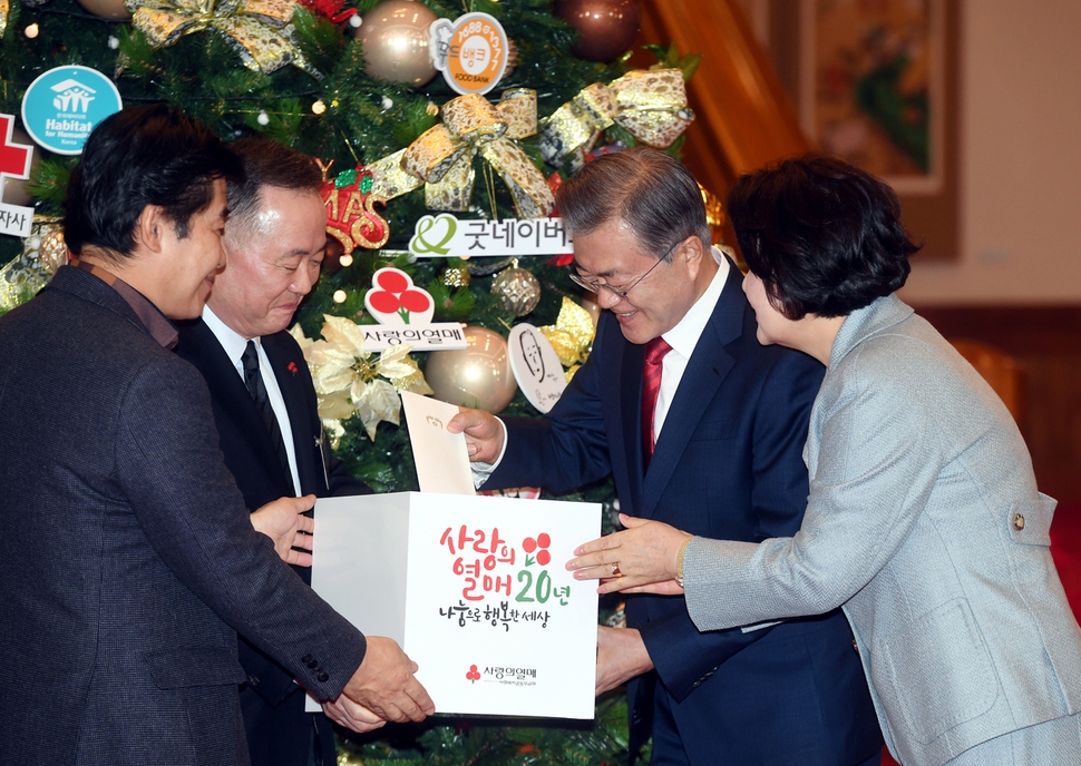 문재인 대통령과 김정숙 여사가 7일 청와대 본관 로비에서 열린 ‘청와대와 함께 메리 크리스마스' 행사에서 기부나눔 단체별 모금함에 성금을 기부하고 있다. 청와대사진기자단