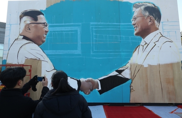 지난 7일 오후 서울 종로구 청와대 앞 사랑채 부근에 문재인 대통령과 김정은 북한 국무위원장이 악수하는 모습을 그린 작품이 설치돼 눈길을 끌고 있다. 연합뉴스