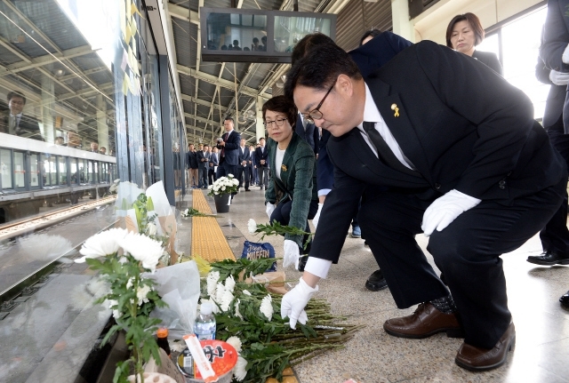 지난해 구의역 사고 1주기를 맞아 우원식 더불어민주당 의원이 서울 광진구 지하철 2호선 구의역 9-4승강장을 찾아 추모 헌화를 하고 있다. 2016년 5월28일 구의역 9-4승강장에서 비정규직 노동자 김군(19)이 안전문을 고치다 사고를 당해 유명을 달리했다. 사진 공동취재단