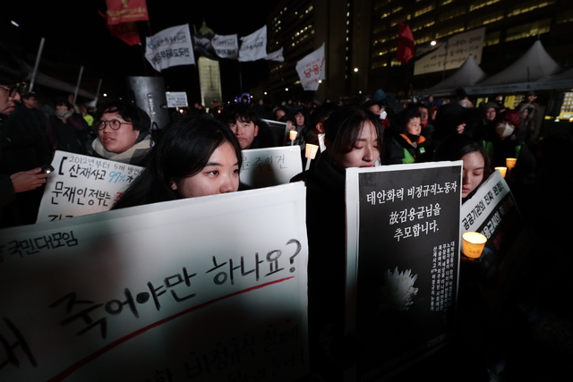 지난 11일 새벽 홀로 일하다 숨진 태안화력 비정규직 노동자 김용균씨 추모 문화제가 13일 밤 서울 광화문광장에서 열려 참석자들이 고인을 추모하는 촛불과 손팻말을 들고 있다. 김명진 기자 littleprince@hani.co.kr