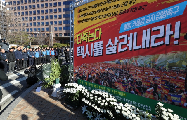 전국택시노동조합연맹과 전국민주택시노동조합연맹, 전국개인택시운송사업조합연합회, 전국택시운송사업조합연합회 등 택시 4개 단체 회원들이 지난 12일 오전 서울 여의도 국회 앞에 지난 10일 카카오티(T)의 카풀 앱 서비스에 항의에 분신 사망한 택시 노동자 최우기씨를 추모하는 분향소를 설치한 뒤 추모 행사를 하고 있다. 김정효 기자 hyopd@hani.co.kr