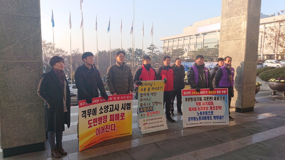 17일 경기도청 신관 앞에서 경기도 산하 3개 공무원 노조가 경기도의 소양고사 시험에 반대하는 팻말을 들고 시위를 벌이고 있다. 경기도청 공무원노조 제공