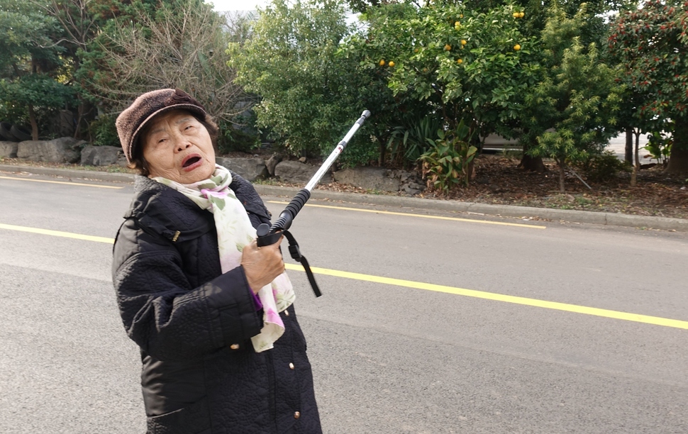 제주4·3후유장애인인 김순혜씨가 12살 때인 1948년 11월 폭탄 파편을 맞은 뒤 기어가 기대앉았던 곳을 가리키고 있다.