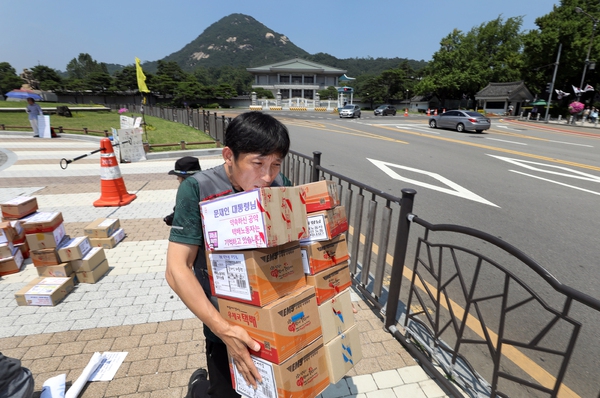 정부가 택배 기사 등 특수고용노동자를 국민연금 지역가입자에서 사업장 가입자로 전환하는 방안을 추진한다고 24일 발표했다. 사진은 민주노총 서비스연맹 전국택배연대노동조합이 지난 6월 20일 서울 종로구 청와대 분수대 앞에서 기자회견을 열고 “택배 노동자들이 장시간 근로에 시달리고 있다”며 노동자들의 가족사진이 들어있는 택배상자 150개에 담아 청와대에 전달하는 모습. 정용일 기자