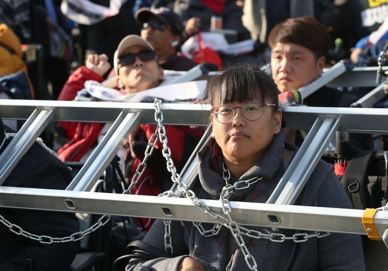장애인들이 지난달 14일 국회 앞에서 장애등급제 폐지를 요구하며 사다리와 쇠사슬로 몸을 묶고 농성하고 있다. 박종식 기자 anaki@hani.co.kr