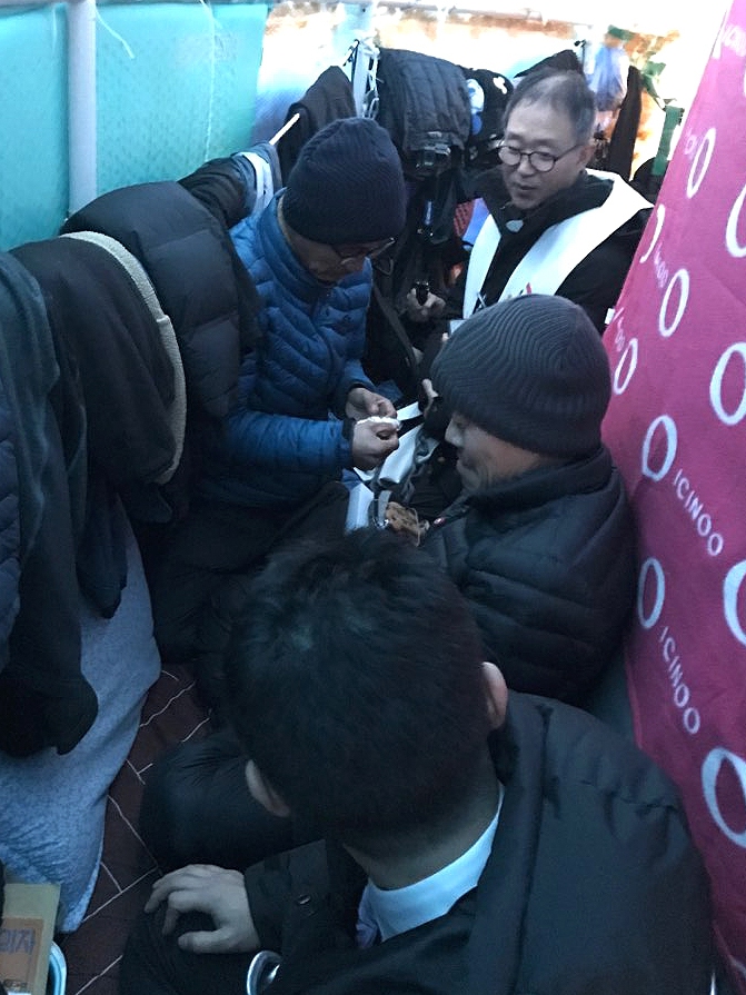 서울 양천구 서울에너지공사 열병합발전소 굴뚝에서 농성을 벌이고 있는 금속노조 파인텍지회 박준호 사무국장(왼쪽)과 홍기탁 전 지회장이 25일 오후 굴뚝 위로 올라온 나승구 천주교 정의구현사제단 신부한테서 아기예수 조각품을 받고 있다. 스타플렉스(파인텍)공동행동 제공