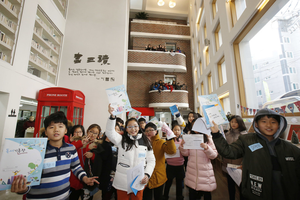 서울 은평구 구립 구산동도서관마을을 찾은 청소년들이 큰 골목길(광장)에서 독서기록장을 들어보이며 활짝 웃고 있다. 이정아 기자 leej@hani.co.kr