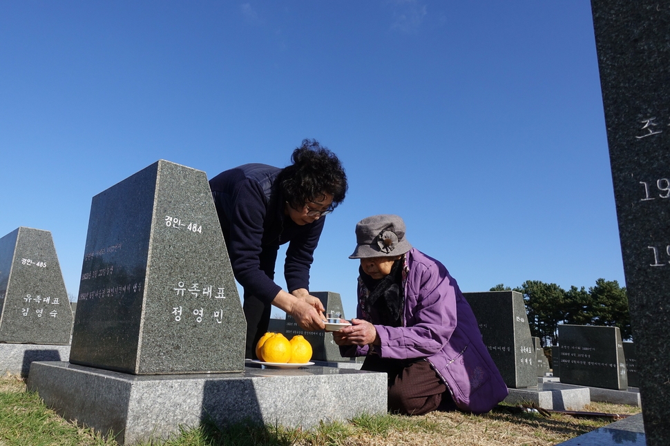 이임규 할머니가 지난 23일 제주시 4·3평화공원 내 행방불명인 표지석에서 딸과 함께 남편의 비석에 잔을 올리고 있다.