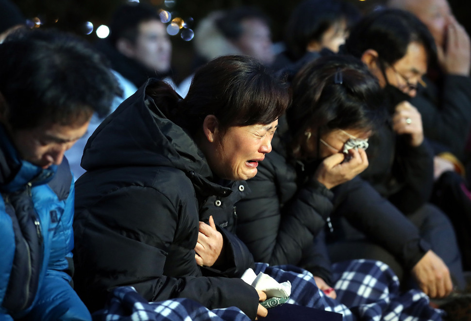 지난 22일 오후 서울 중구 파이낸스센터 앞에서 열린 ‘김용균 범국민추모제’에서 고 김용균씨 어머니 김미숙씨(왼쪽 둘째)가 눈물을 흘리고 있다. 김씨 오른쪽은 실습 도중 사고로 숨진 이민호군의 부모. 신소영 기자