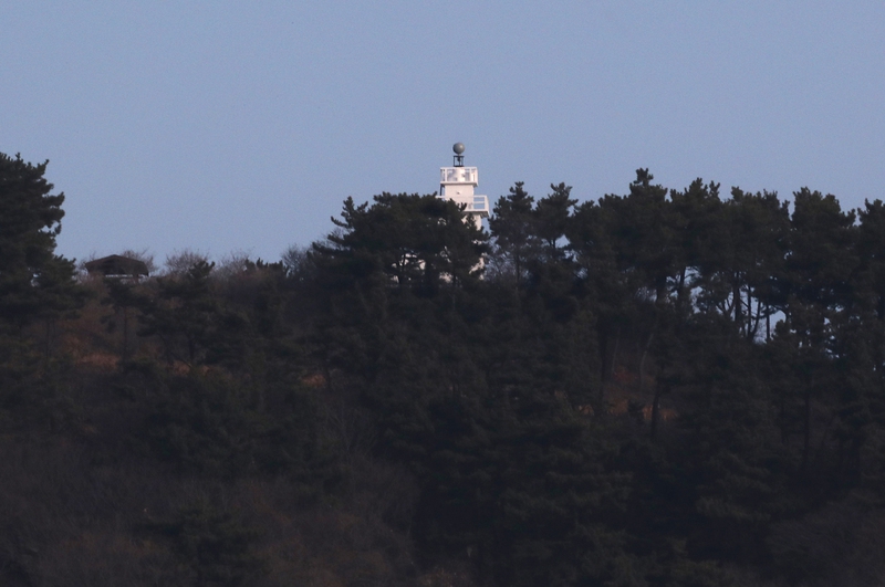 바다에서 바라본 연평도등대가 섬의 서남단 언덕 위에서 소나무들에 가려져 있다. 연평도/강재훈 선임기자 khan@hani.co.kr