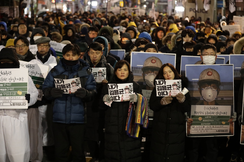 태안화력발전소 청년 비정규직 노동자 고 김용균씨 어머니 김미숙씨와 시민들이 29일 오후 2차 범국민 추모제를 마친 뒤 청와대 들머리까지 행진한 뒤 ‘내가 김용균이다’라는 문구가 새겨진 손팻말을 들고 있다.