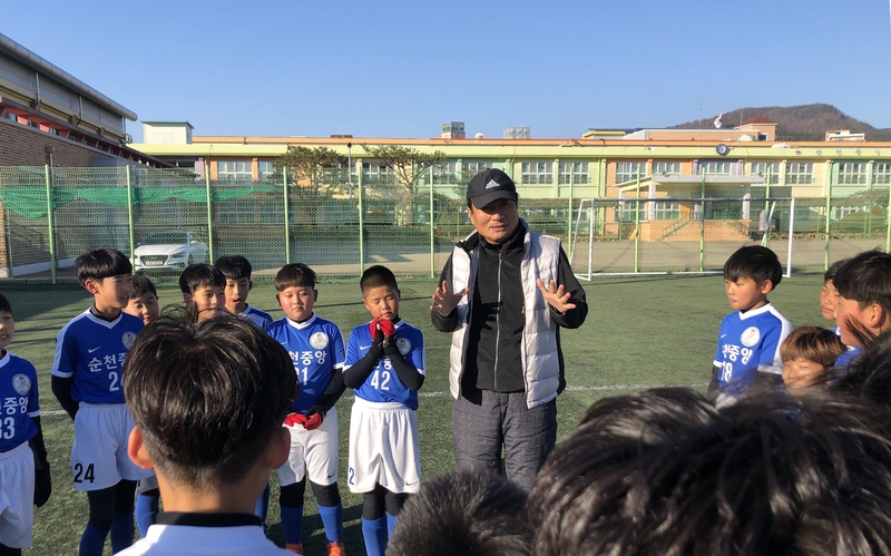 정한균 순천중앙초 축구부 감독이 2일 새해 첫 훈련을 시작한 선수들과 이야기를 나누고 있다.