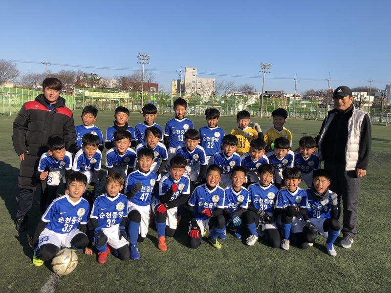 정한균 순천중앙초 축구부 감독이 2일 학교 인조잔디 경기장에서 선수들과 함께 카메라 앞에 섰다.