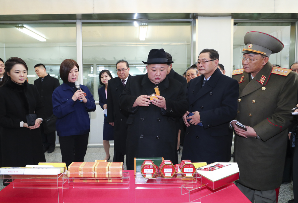 김정은 북한 국무위원장(가운데)이 9일 중국 베이징에서 생약 제조업체인 동인당의 제품들을 살펴보고 있다. 베이징/신화 연합뉴스