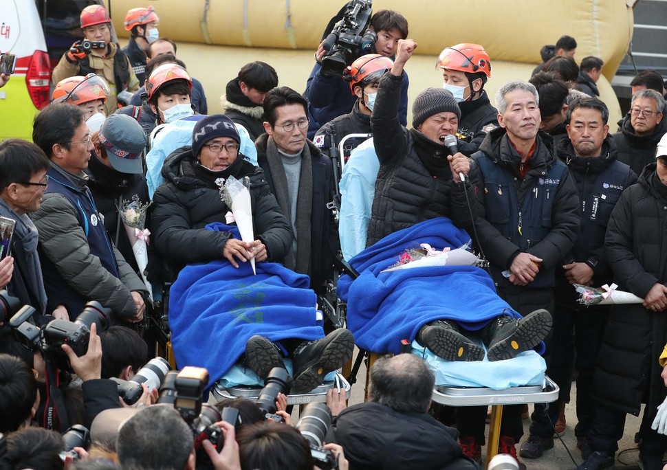 파인텍 노사 협상이 극적으로 타결된 11일 금속노조 파인텍지회 홍기탁 전 지회장(오른쪽)과 박준호 사무장이 서울 양천구 서울에너지공사 75m 높이 굴뚝에서 426일째 농성을 끝내고 내려와 소감을 밝힌 뒤 “청춘을 다 바쳤다 민주노조 사수하자 투쟁!”이라고 구호를 외치고 있다. 박종식 기자 anaki@hani.co.kr