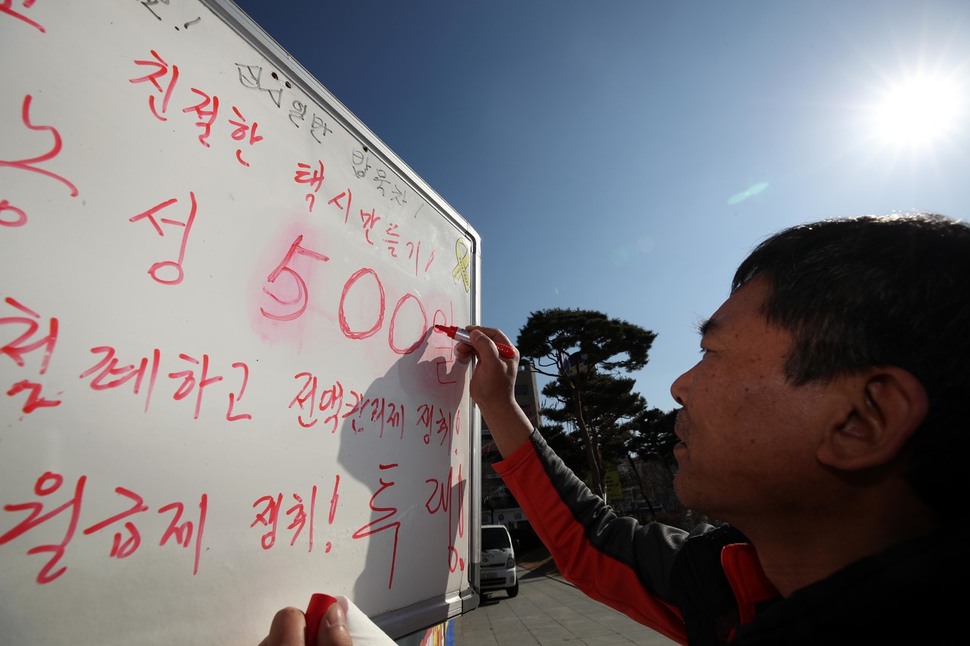 고공농성 사수조 일일 담당인 송민섭 공공운수 택시지부 대성교통 분회장이 농성장 게시판에 500일로 농성일수를 고쳐 쓰고 있다. 전주/김봉규 선임기자 bong9@hani.co.kr