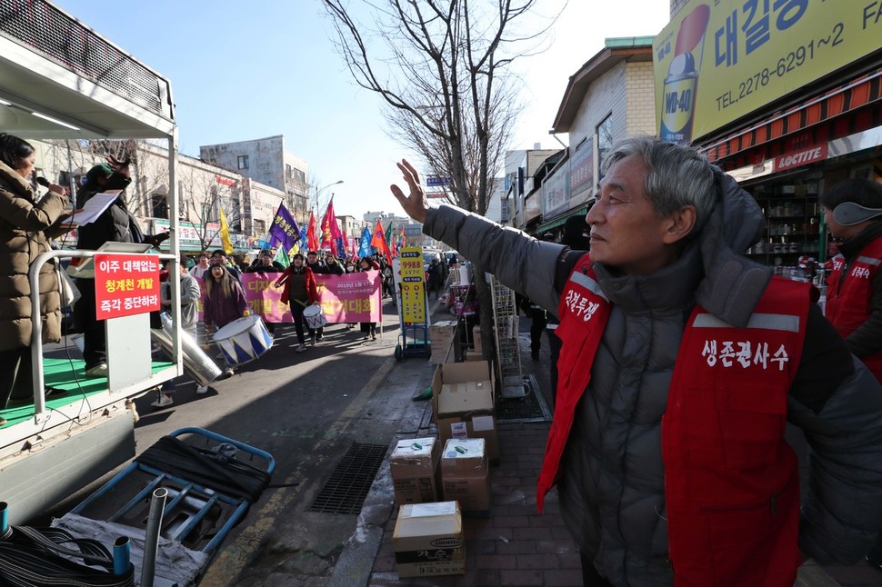 17일 오후 서울 중구 청계천 공구상가 일대에서 청계천 을지로 재개발 반대 총궐기 대회를 마친 뒤 행진하는 참가자들을 향해 한 상인이 손을 흔들고 있다. 백소아 기자