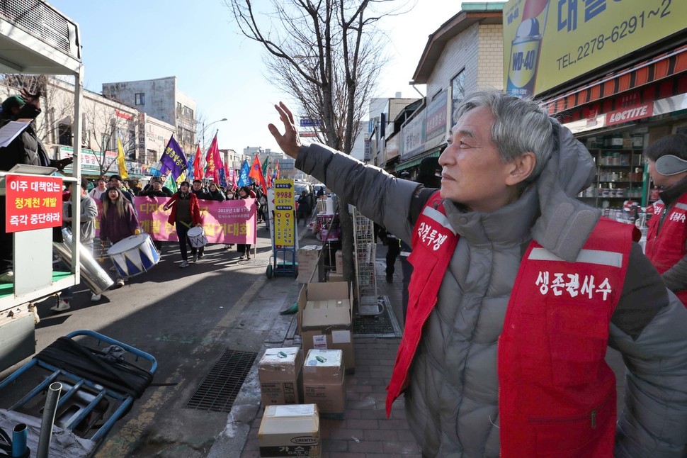 17일 오후 서울 중구 청계천 공구상가 일대에서 청계천 을지로 재개발 반대 총궐기 대회를 마친 뒤 행진하는 참가자들을 향해 한 상인이 손을 흔들고 있다. 백소아 기자 thanks@hani.co.kr