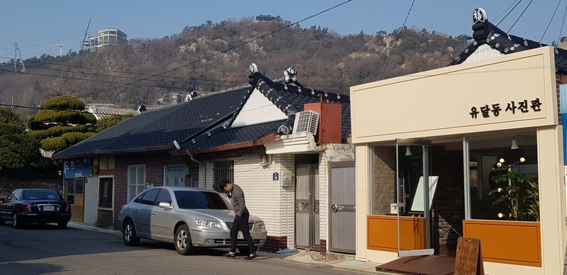 목포 근대역사관(일제 강점기 동양척식주식회사 건물) 맞은편 새롭게 문을 연 사진관이 보인다. 왼편 검은 지붕 뒤로, 현재 카페로 개조된 근대식 주택의 정원과 지붕이 살짝 엿보인다. 목포/정유경 기자