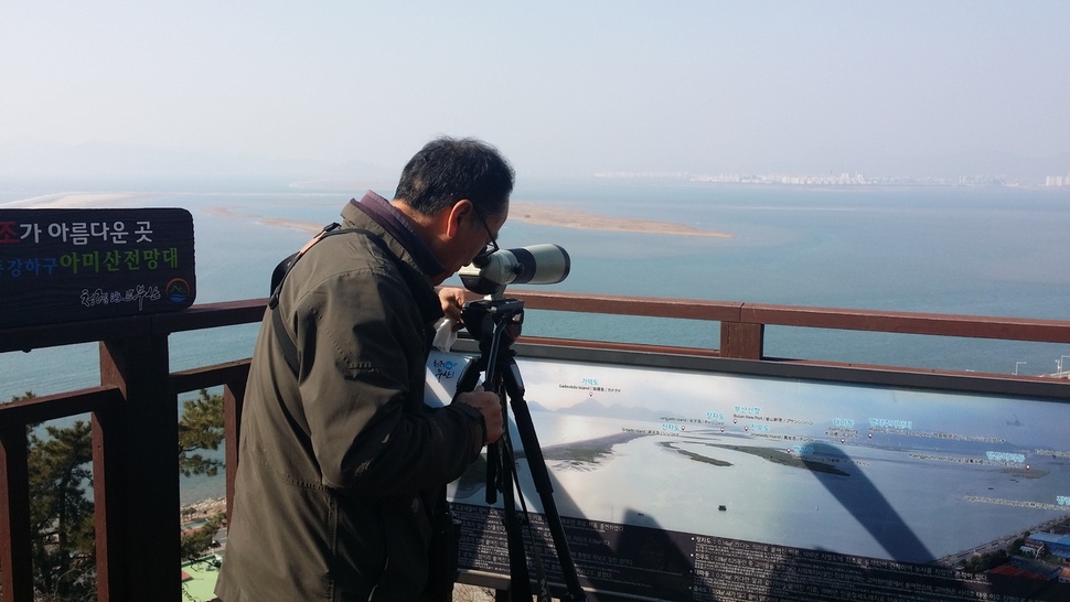 27일 부산 사하구 다대동 아미산전망대에서 박중록 습지와새들의친구 운영위원장이 낙동강 하류에 모인 고니를 망원경으로 살펴보고 있다. 김영동 기자