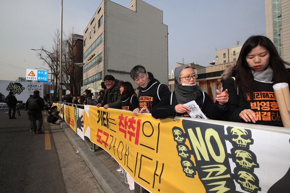 정리해고 13년째 거리 농성을 벌이고 있는 콜텍 해고 노동자들과 시민단체 회원들이 30일 오후 서울 강서구 등촌동 콜텍 본사 앞에서 기자회견을 마친 뒤 이어붙인 펼침막 앞에서 집회를 열고 있다. 김봉규 선임기자