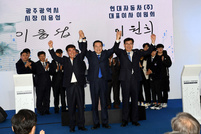 이용섭 광주시장(가운데), 이원희 현대자동차 대표(오른쪽), 윤종해 한국노총 광주본부장이 31일 오후 광주시청에서 열린 ’광주형 일자리 투자 협약식’에 참석해 디지털 서명을 마친 뒤 문재인 대통령을 비롯한 참석자들 앞에서 손을 맞잡아 번쩍 들어 보이고 있다. 청와대사진기자단