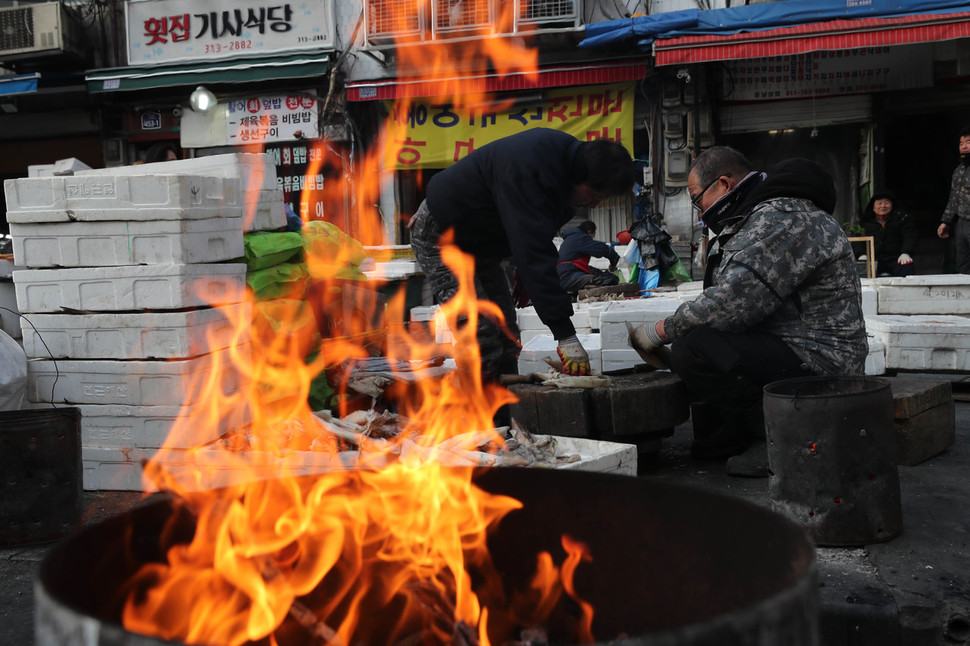 전국 대부분 지역에 한파주의보가 내려진 8일 아침 서울 중구 중림시장에서 상인들이 모닥불을 옆에서 일을 하고 있다. 백소아 기자