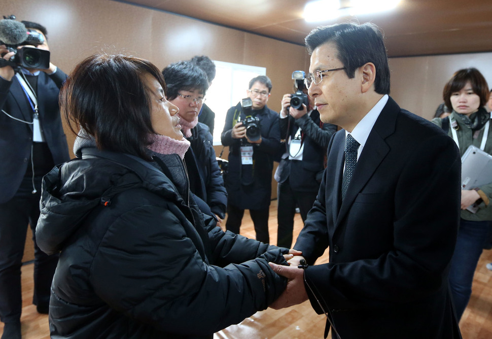 법무부 장관 시절 해경 수사를 틀어막았던 황교안 전 총리가 대통령 권한대행이던 2017년 4월1일 세월호 선체가 있는 전남 목포신항을 방문해 미수습자 가족의 손을 잡고 있다. 청와대사진기자단