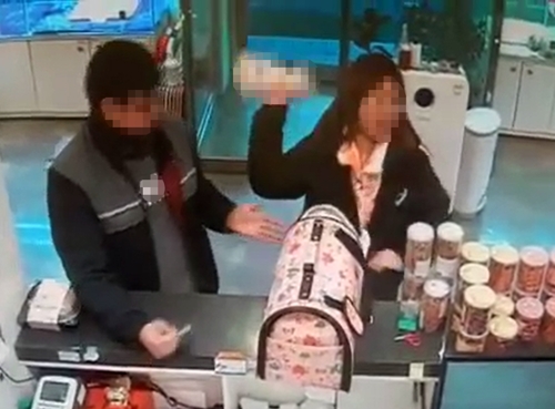 식분증을 이유로 애견분양 가게에서 분양받은 강아지를 던지는 여성. 해당 가게 CCTV 화면 갈무리