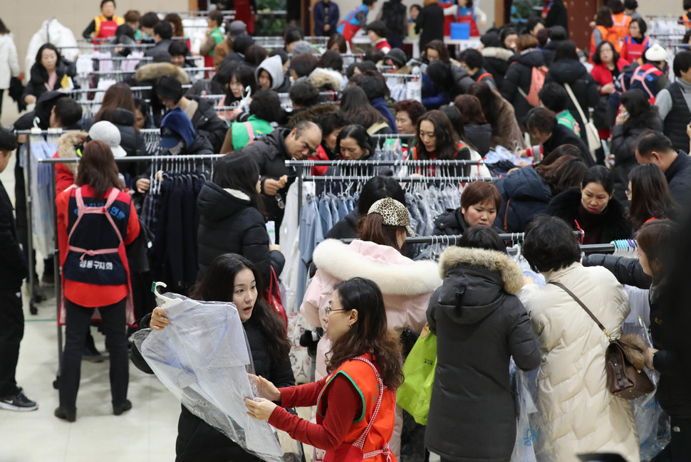 14일 오전 서울 성동구청에서 열린 ‘사랑의 교복 나눔장터’를 찾은 시민들이 자녀의 교복을 고르고 있다. 백소아 기자