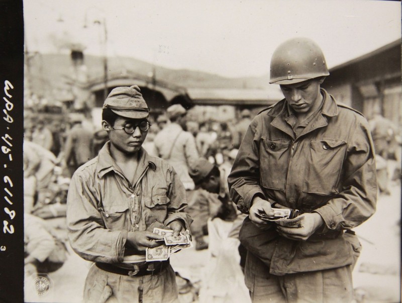 1945년 10월12일 부산항에서 미군이 일본으로 돌아가는 배를 기다리는 일본군 한명이 소지한 현금을 점검하고 있다. 일본으로 송환되는 일본인이 소지할 수 있는 돈은 민간인은 1000엔, 군 장교는 500엔, 사병은 250엔이 상한선이었다. 미국 국립문서관, 국사편찬위 전자사료관 사본