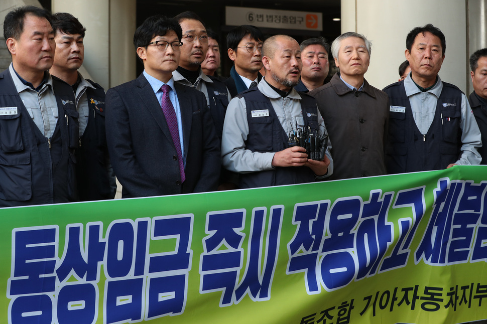 강상호 금속노조 기아자동차지부장(앞줄 왼쪽 셋째)과 지부 임원, 변호인단 등이 22일 오후 서울 서초동 서울고등법원에서 ‘기아차 통상임금’ 항소심 선고 뒤 입장을 밝히고 있다. 김정효 기자 hyopd@hani.co.kr