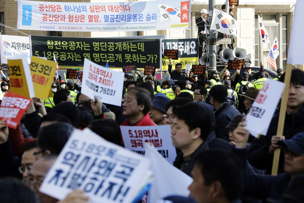 범국민대회를 마친 집회 참가자들이 23일 오후 서울 세종로 네거리에서 행진을 하고 있다. 극우단체 회원들이 행진대열 뒤에서 5.18유공자 명단 공개를 요구하는 시위를 하고 있다.