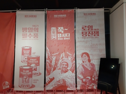 ‘…메이드인 조선’전에 차려진 팝업프로젝트 매장 ‘평양슈퍼마케트’에 내걸린 북한스타일의 제품 홍보포스터들. 매장에서는 평양사람들의 라이프스타일을 팝아트 스타일로 반영한 일상용품, 패션상품을 판다.