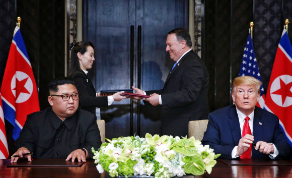 역사적인 첫 북-미 정상회담이 열린 2018년 6월12일 오후 싱가포르 센토사섬 카펠라호텔에서 북한 김여정 노동당 제1부부장과 미국 마이크 폼페이오 국무장관이 김정은 국무위원장과 도널드 트럼프 대통령이 서명한 공동합의문을 교환하고 있다. 연합뉴스