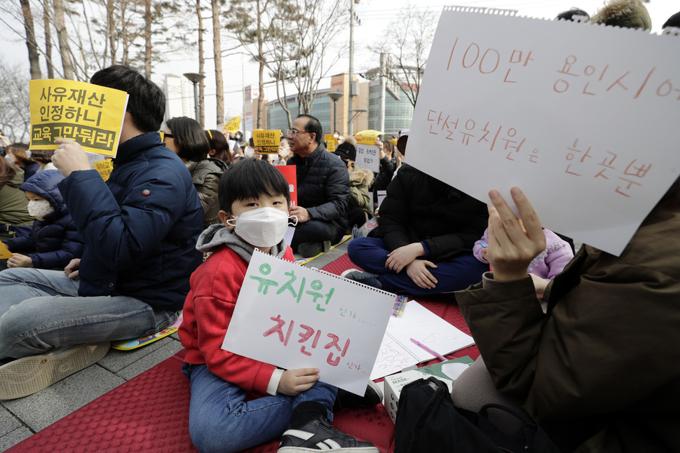 한 아이가 ‘유치원인가… 치킨집인가…’라는 문구가 적힌 손팻말을 들고 있다.